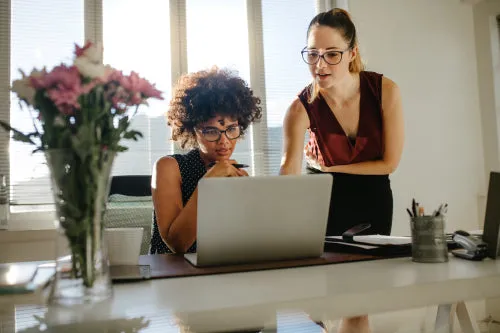 Business colleagues discussing working over a laptop